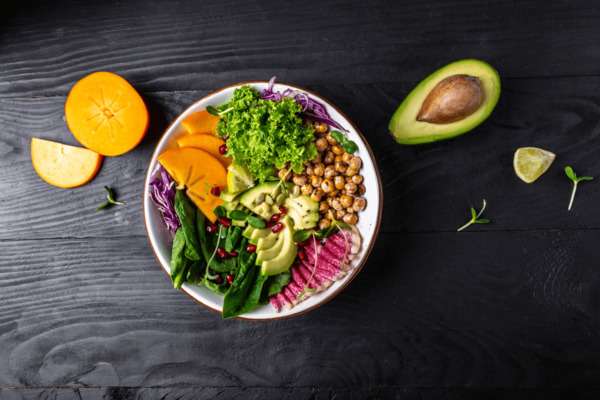 Plato colorido con verduras frescas sobre una mesa clara